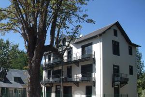 ein weißes Gebäude mit einem Baum davor in der Unterkunft APPARTEMENT T2 neuf ☆☆☆ proche ARGELES GAZOST in Beaucens