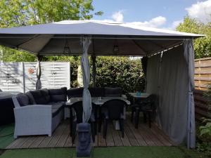a tent with a table and chairs on a deck at Location saisonniere in Cozes