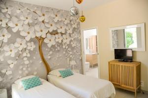 ein Schlafzimmer mit 2 Betten und einem Baum an der Wand in der Unterkunft GIULIA, Villa d'exception, Piscine vue mer - Porticcio in Porticcio