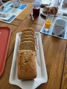 a loaf of bread on a white plate on a table at Chez Tib in Trégunc