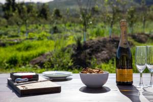 a bottle of wine and a bowl of nuts on a table at 20 Good Summers Farm Stay in The Crags