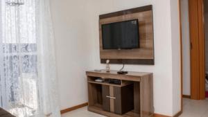 sala de estar con TV en la pared en Lindo Apartamento, amplo e confortável, Penha Santa Catarina,, en Penha