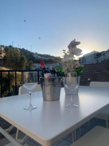 un tavolo con due bicchieri e una bottiglia di vino di El Balcón de la Roca a Setenil