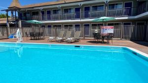 a large blue swimming pool with chairs and umbrellas at SureStay Hotel by Best Western Santa Cruz in Santa Cruz