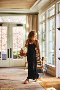 Una mujer con un vestido negro caminando en una habitación en The Pinch Charleston en Charleston