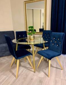 comedor con mesa de cristal y sillas azules en Apartament Morski MALOVES, en Władysławowo