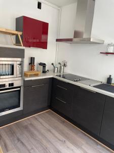 cocina con electrodomésticos en blanco y negro y suelo de madera en La Madeleine, en Annecy