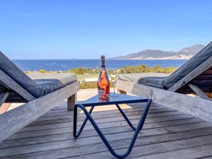 eine Flasche Wein auf einem Tisch auf einem Deck in der Unterkunft GIULIA, Villa d'exception, Piscine vue mer - Porticcio in Porticcio