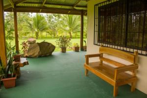a porch with a bench and a large rock at Green House in Samen +3 photos