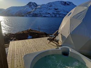 a bath tub with an umbrella next to a body of water at Isbreen The Glacier in Jøkelfjord