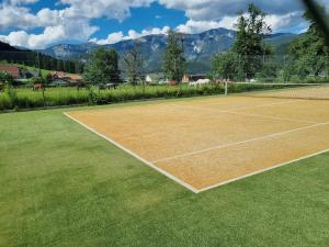a tennis court with mountains in the background at Apartment Seebachhof in Edlbach