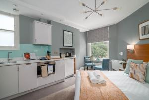 een keuken met een bed in een kamer bij 5 Doughty Street - Urban Apartments in Londen