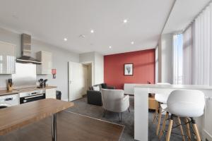 een keuken en een woonkamer met een tafel en stoelen bij K Suites - Waveney Chambers 1 in Lowestoft