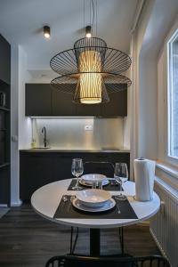 a table with two glasses and a chandelier in a kitchen at Strict city apartments in Ljubljana