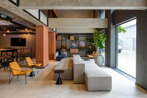 a lobby with a couch and chairs and a table at Ibis Budget Balneario Camboriu in Balneário Camboriú