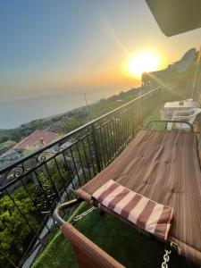un banco en un balcón con la puesta de sol en el fondo en Il Panorama en Buonvicino