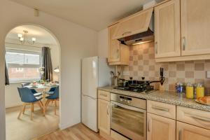 cocina con nevera y mesa con sillas en K Suites - Duke St Bridgwater, en Bridgwater