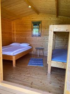 Cabaña de madera con 2 camas y mesa. en Mini Camping en Kabli