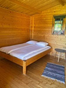 Cabaña de madera con cama en una habitación en Mini Camping, en Kabli