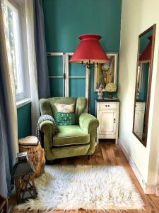 un salon avec une chaise verte et une lampe rouge dans l'établissement Le Stanze di Matilde, à Crevalcore