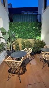 un patio avec des chaises et des tables ainsi qu'un mur vert dans l'établissement Lindo apartamento em zona central, Batalha - Porto, à Porto