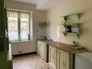 cocina con encimera, fregadero y ventana en Treignac Tourelles, en Treignac
