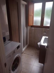 ein kleines Bad mit einer Waschmaschine in der Unterkunft La casina de Pichi in Caravia + 33 Fotos