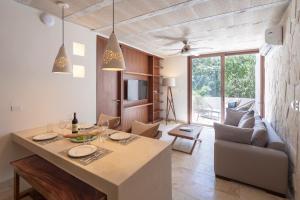a kitchen and living room with a table and a couch at Kiki Tulum in Tulum