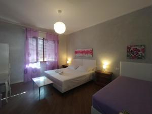 a bedroom with a bed and a table and two beds at B&B Villa la Bouganville in Camaiore