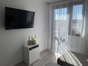 a white room with a television on a wall with a window at Apartmán TiSa in Liptovský Trnovec