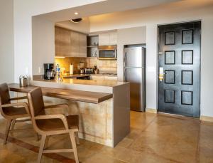 a kitchen with a refrigerator, stove, sink and cabinets at Grand Fiesta Americana Los Cabos All Inclusive Golf & Spa in Cabo San Lucas