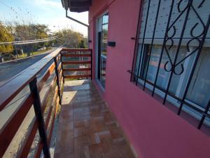 un balcón de una casa rosa con una valla en Lo de Lio y Titi en San Clemente del Tuyú