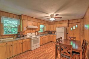 een keuken met houten kasten, een tafel en een plafondventilator bij Charming Blue Ridge Mtn Cottage about 4 Mi to Hiking! in Marshall