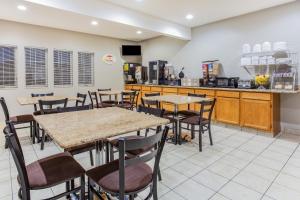 a restaurant with tables and chairs and a kitchen at Super 8 by Wyndham Iowa Falls in Iowa Falls