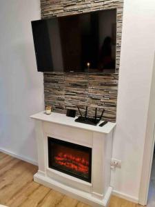 una chimenea con TV encima en Lovely 3-bedroom apartment in the city center en Timisoara