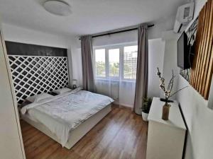 a bedroom with a bed and a large window at Lovely 3-bedroom apartment in the city center in Timişoara