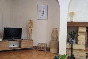 una sala de estar con TV en un centro de entretenimiento de madera en Casa Ludese en Salernes