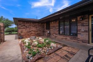 um jardim em frente a uma casa de tijolos em Homestead House - In Shadow Hills Golf Course Division Home em Lubbock