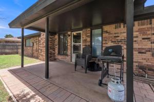 a covered patio with a grill and a brick building at Homestead House - In Shadow Hills Golf Course Division Home in Lubbock