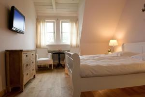 sypialnia z łóżkiem i telewizorem na ścianie w obiekcie Ferienhaus Mohnblume w mieście Krienke