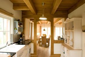 a kitchen with wooden ceilings and a dining room at Ferienhaus Mohnblume in Krienke