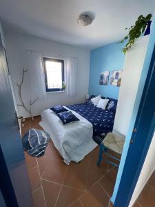 Apartments AS في بريفلاكا: غرفة نوم زرقاء مع سرير وكرسي