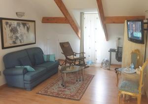a living room with a blue couch and a table at Suite indépendante de 66m2 tout confort et calme in Villefranche-de-Rouergue