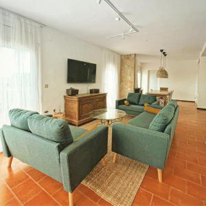 een woonkamer met 2 banken en een tv bij Villa Mas Blau Mar in Lloret de Mar