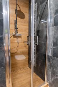 a shower with a glass door in a bathroom at Penzión Kolkáreň in Stará Ľubovňa