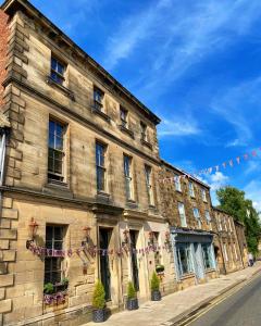 an old building with a bunch of flags on it at Newgate House in Morpeth