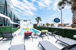a swimming pool with chairs and a pool table at 300 Tenth in Myrtle Beach