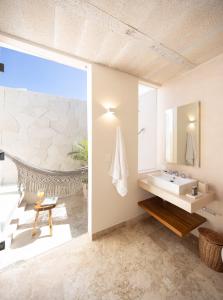 a bathroom with a sink and a mirror at Kiki Tulum in Tulum