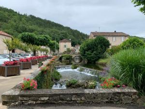 a small town with a waterfall and flowers at Spacious apartment in a charming, tranquil village in Saint-Vincent-Rive-dʼOlt