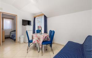 a dining room with a table and blue chairs at 2 Bedroom Lovely Apartment In Punta Kriza in Punta Križa